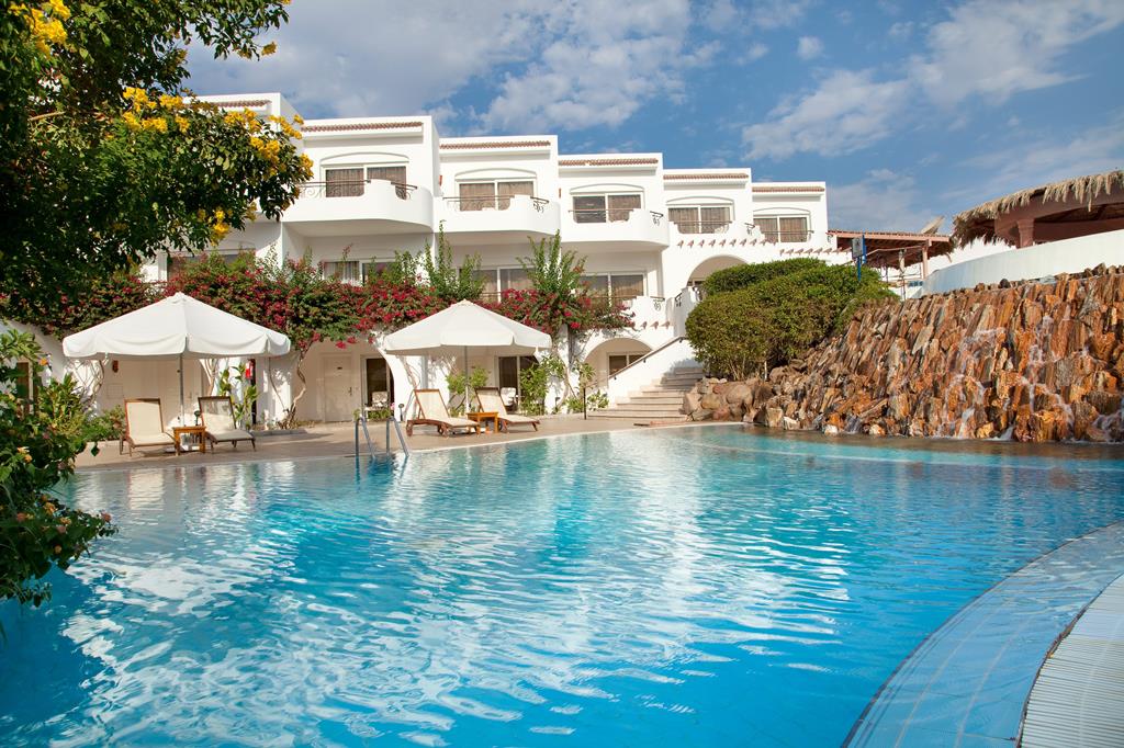 Luxe zwembad met witte accommodaties erachter